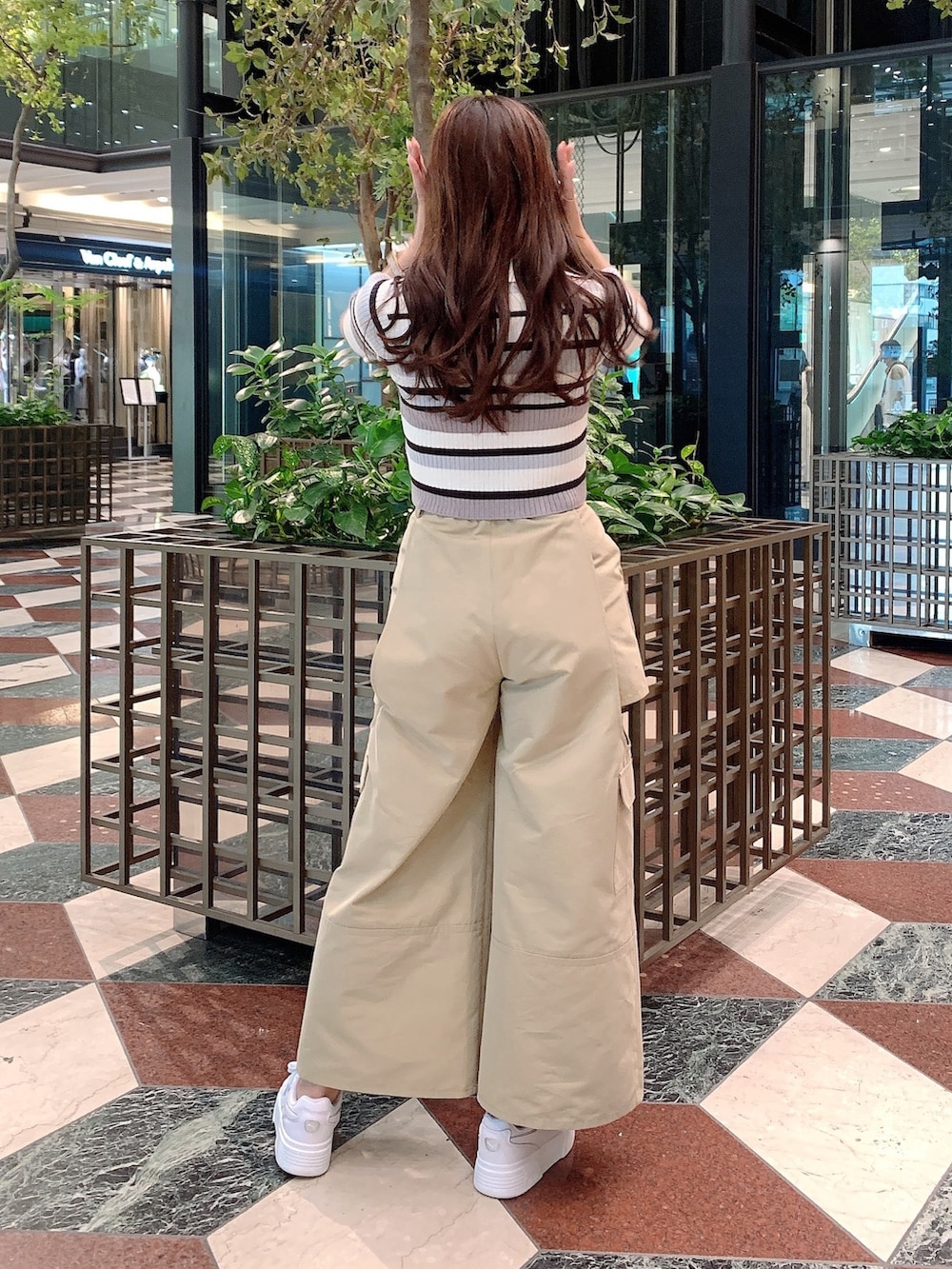 ベージュ系のチノパンツ、グレー系のニット/セーターを着用したレディースの春コーディネートの7枚目の写真