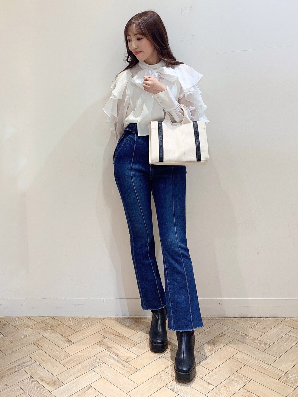 ホワイト系のシャツ/ブラウス、ブルー系のデニムパンツ、ホワイト系のハンドバッグを着用したレディースの冬コーディネートの2枚目の写真