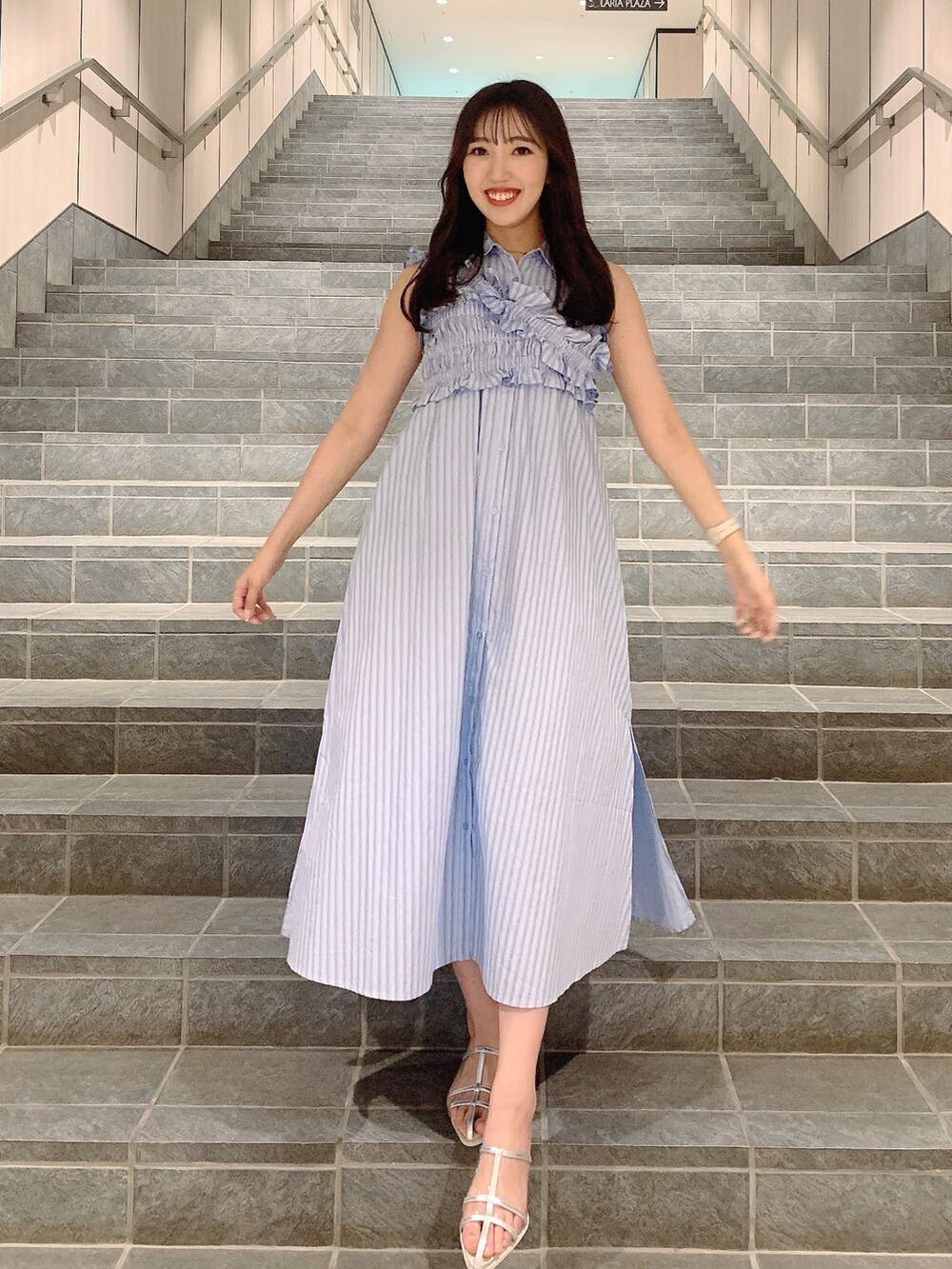 シルバー系のパンプス、ブルー系のシャツワンピースを着用したレディースの夏コーディネートの5枚目の写真
