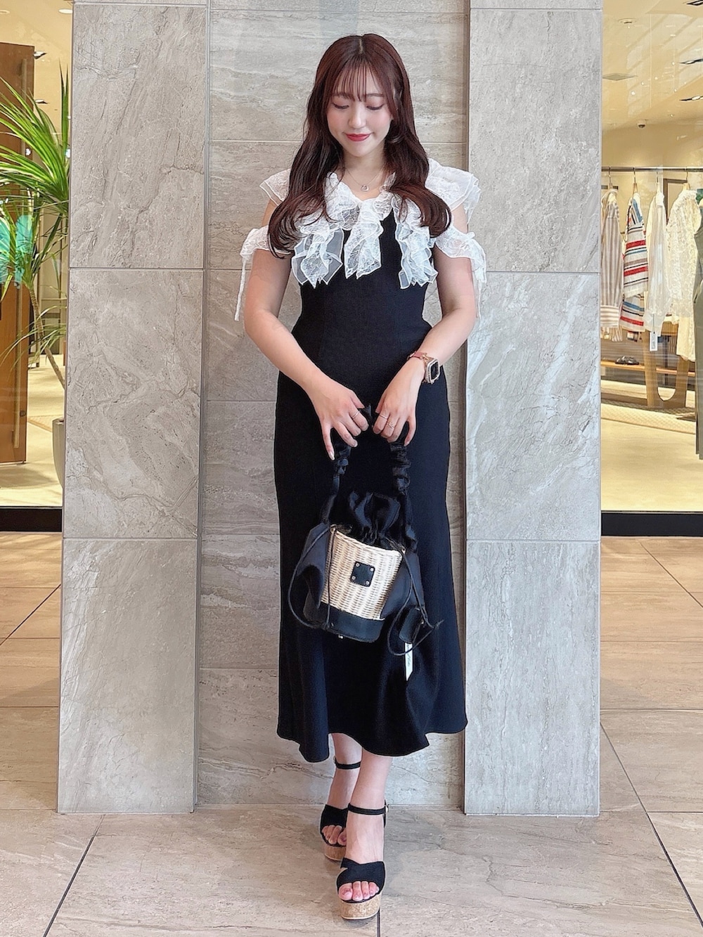 ブラック系のワンピース、ブラック系のサンダル、ブラック系のかごバッグを着用したレディースの夏コーディネートの4枚目の写真