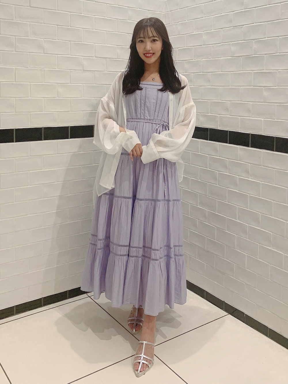 シルバー系のパンプス、パープル系のワンピース、ホワイト系のシャツ/ブラウスを着用したレディースの夏コーディネートの2枚目の写真