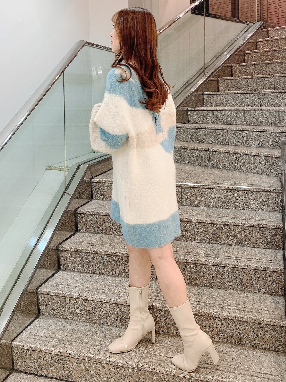 ベージュ系のニット/セーター、ホワイト系のブーツを着用したレディースの秋コーディネートの4枚目の写真