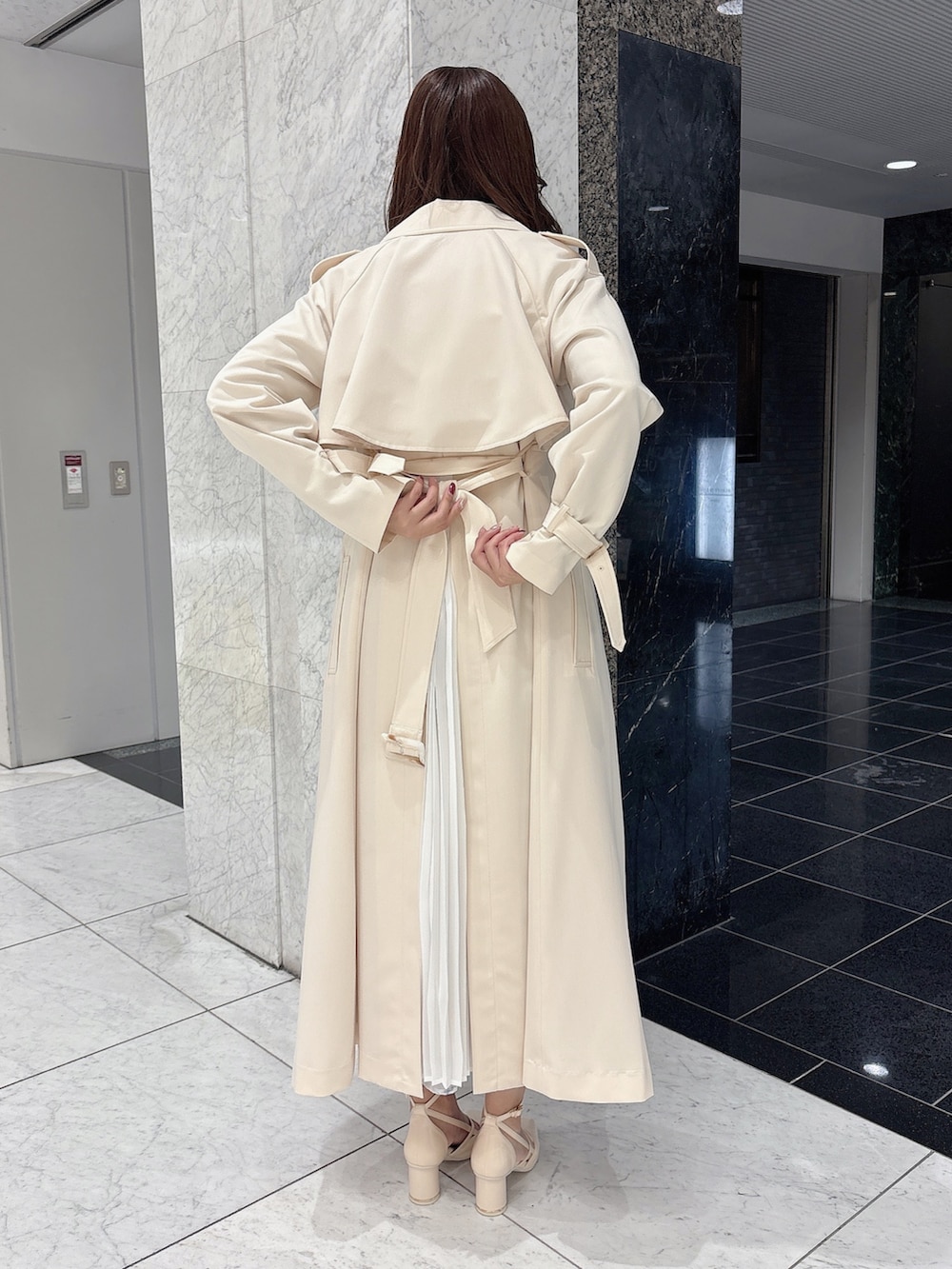 ホワイト系のサンダル、ホワイト系のワンピース、ベージュ系のトレンチコートを着用したレディースの春コーディネートの7枚目の写真