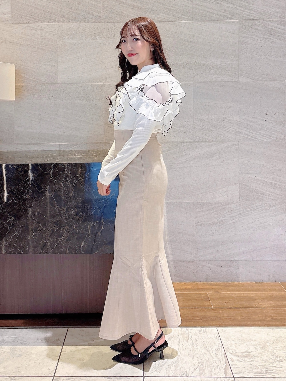 ベージュ系のスカート、ホワイト系のTシャツ/カットソー、ブラック系のパンプスを着用したレディースの春コーディネートの4枚目の写真