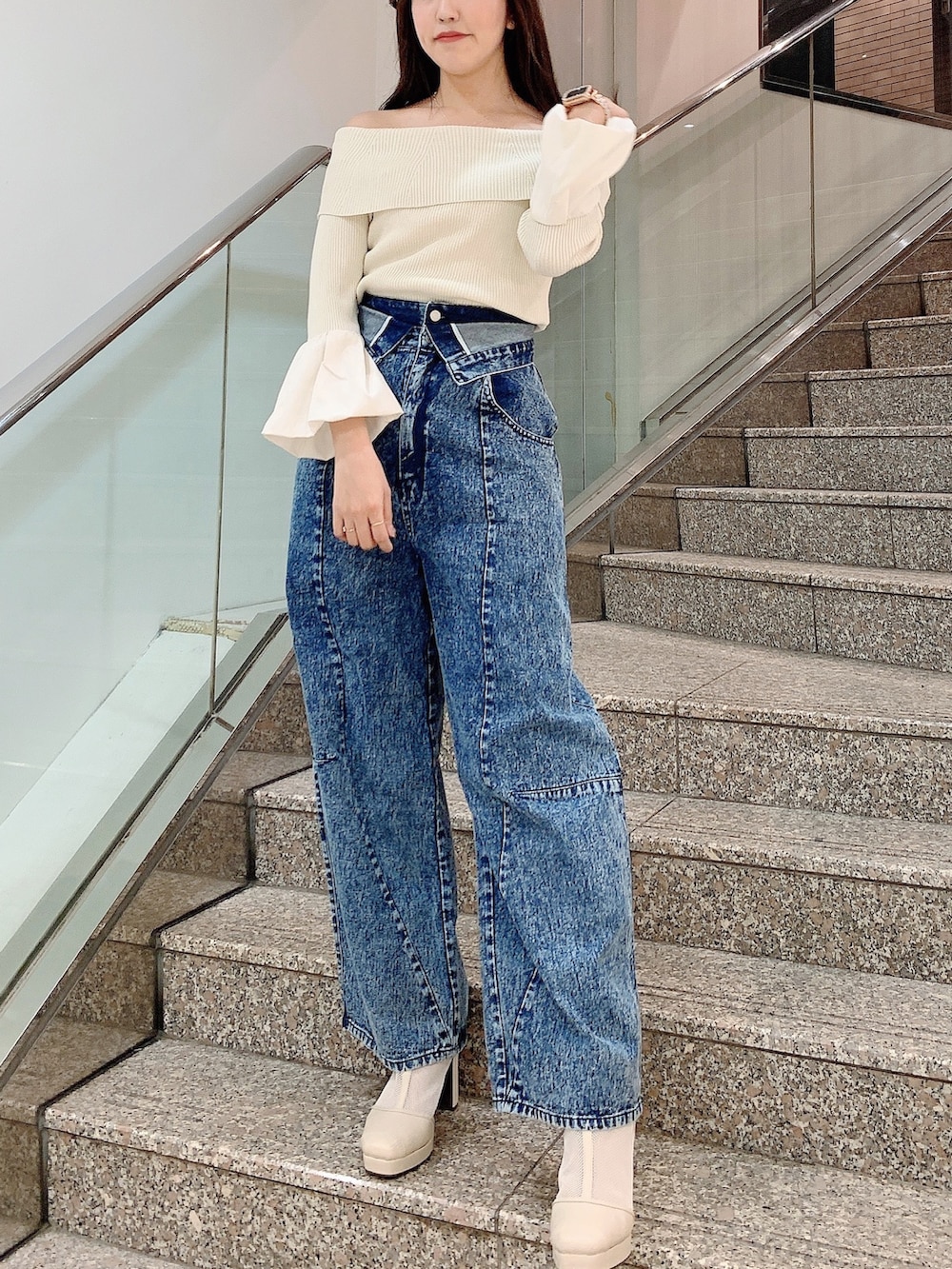 ホワイト系のニット/セーター、その他のデニムパンツ、ホワイト系のブーツを着用したレディースの冬コーディネートの2枚目の写真