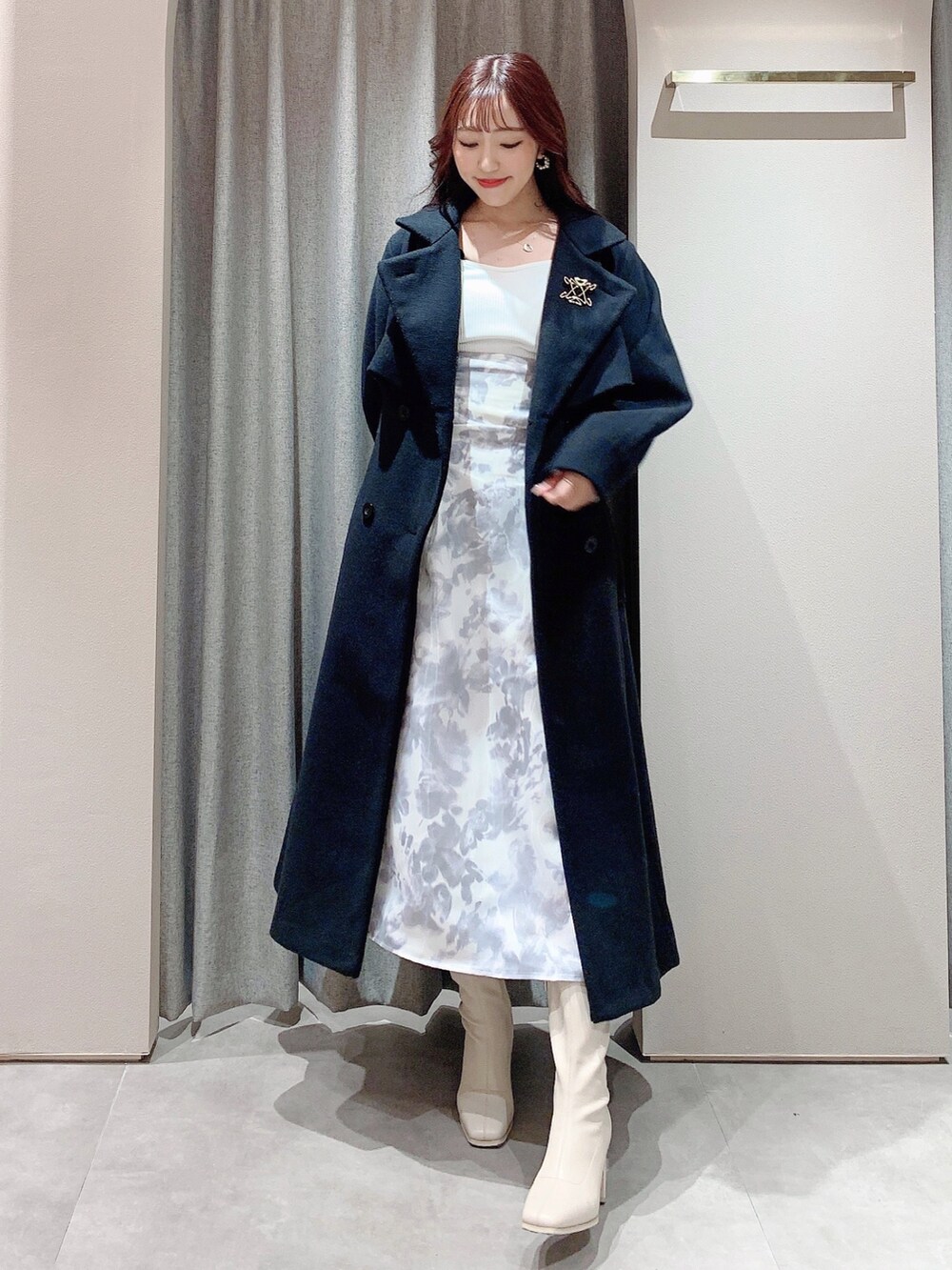 ホワイト系のワンピース、ホワイト系のブーツ、ブラック系のその他アウターを着用したレディースの冬コーディネートの2枚目の写真