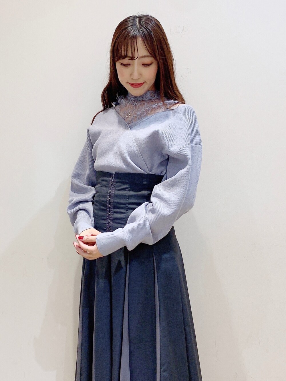 グレー系のスカート、ブルー系のニット/セーター、ホワイト系のブーツを着用したレディースの秋コーディネートの7枚目の写真