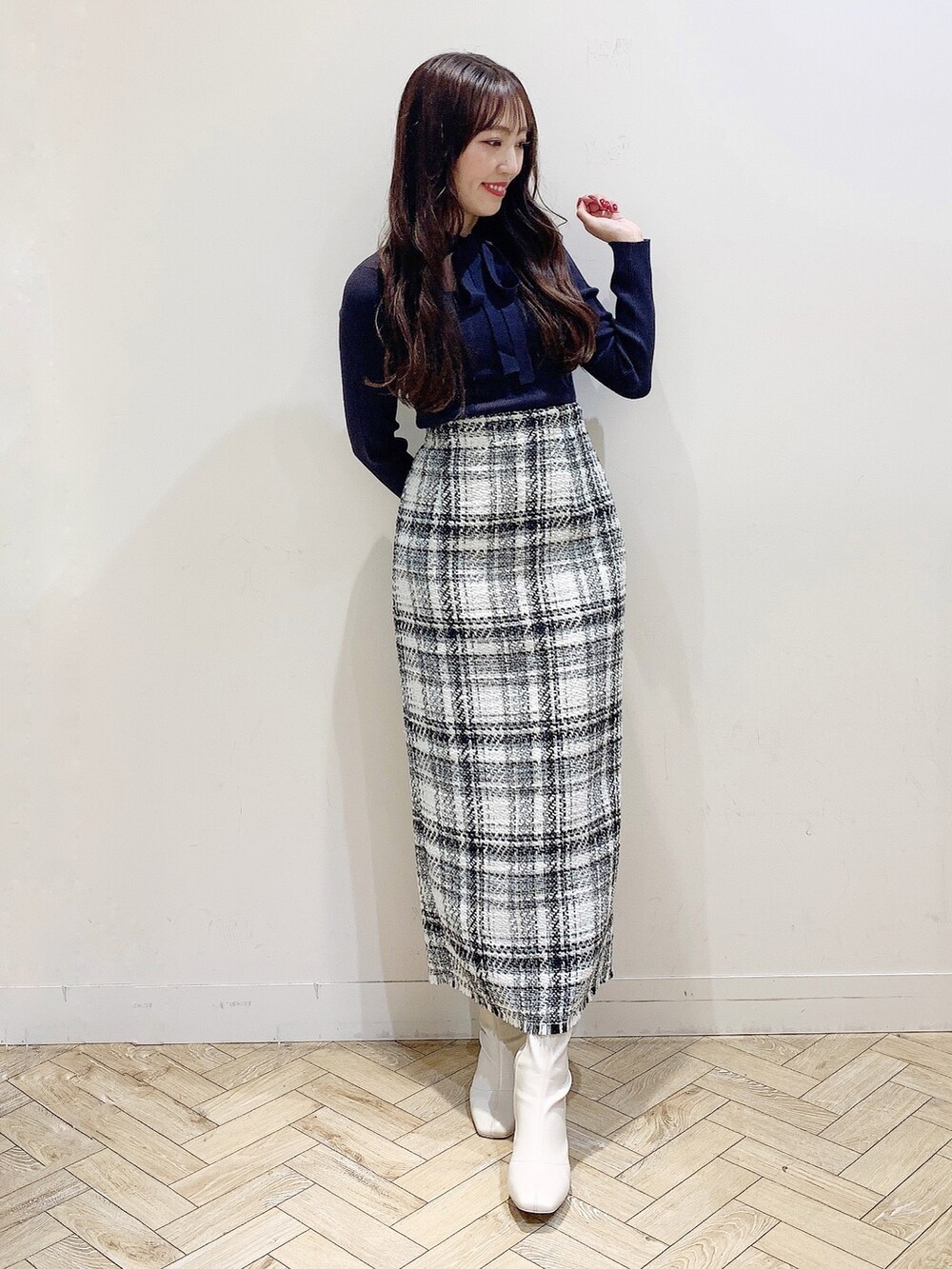 ホワイト系のスカート、ブラウン系のニット/セーター、ホワイト系のブーツを着用したレディースの秋コーディネートの6枚目の写真