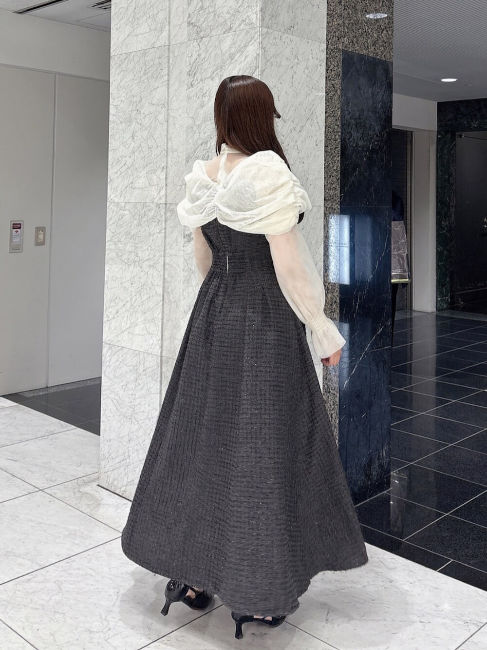 ブラック系のパンプス、ブラック系のドレスを着用したレディースの冬コーディネートの4枚目の写真