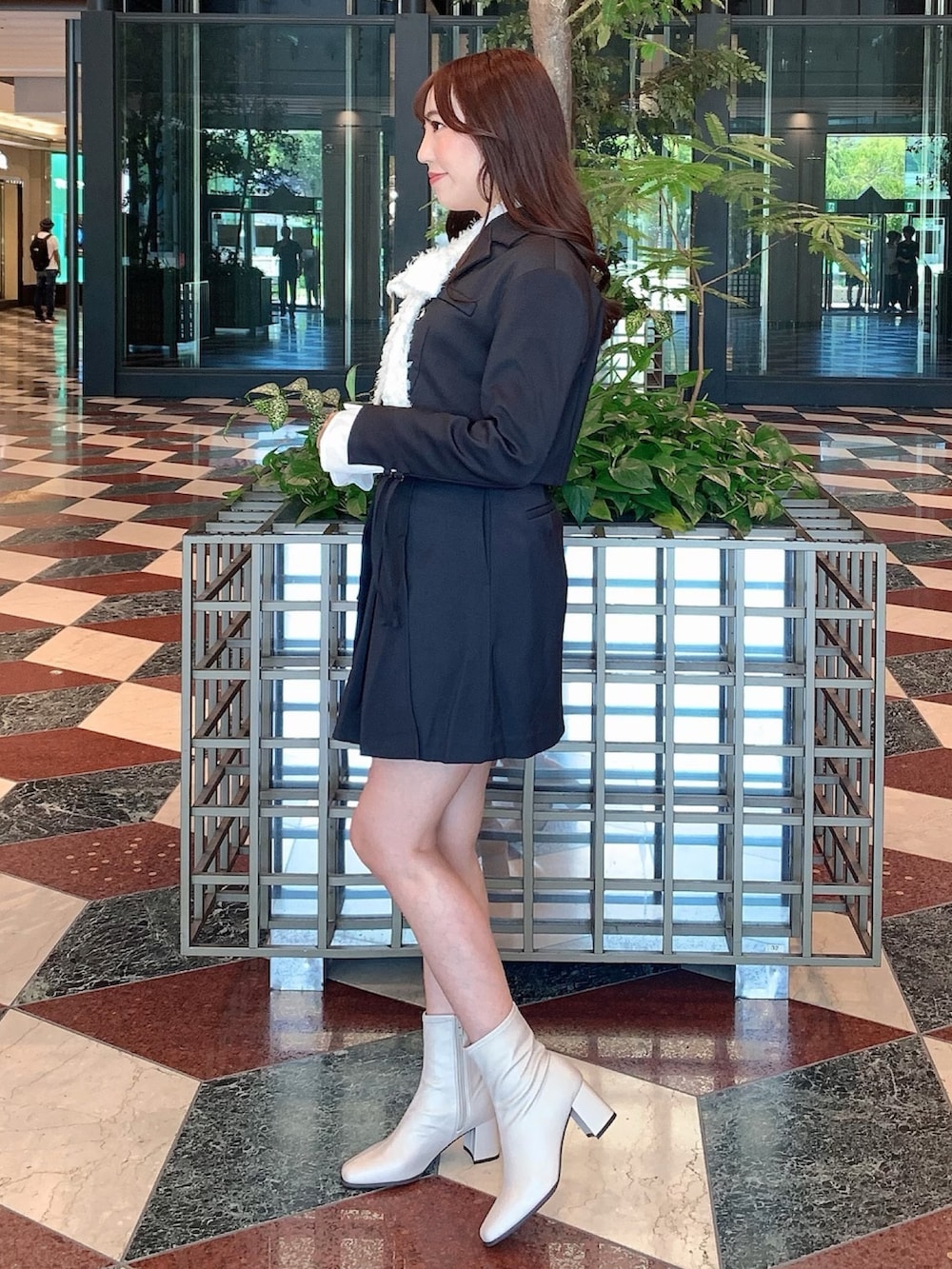 ブラック系のスカート、ブラック系のテーラードジャケット、ベージュ系のブーツを着用したレディースの秋コーディネートの6枚目の写真