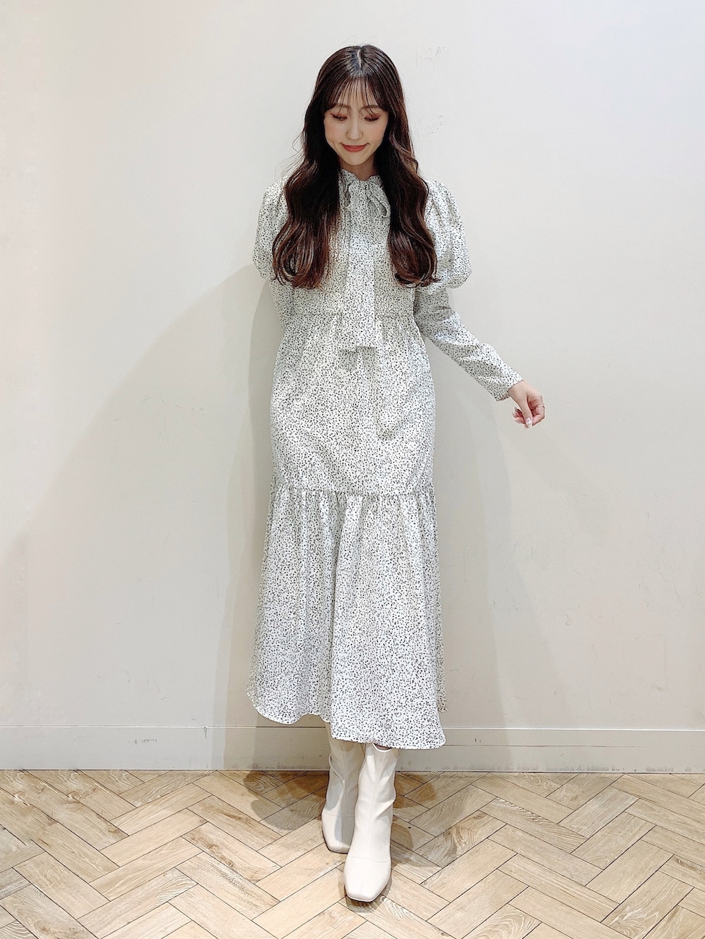 ホワイト系のワンピース、ブラウン系のダウンジャケット/コート、ホワイト系のブーツを着用したレディースの冬コーディネートの2枚目の写真