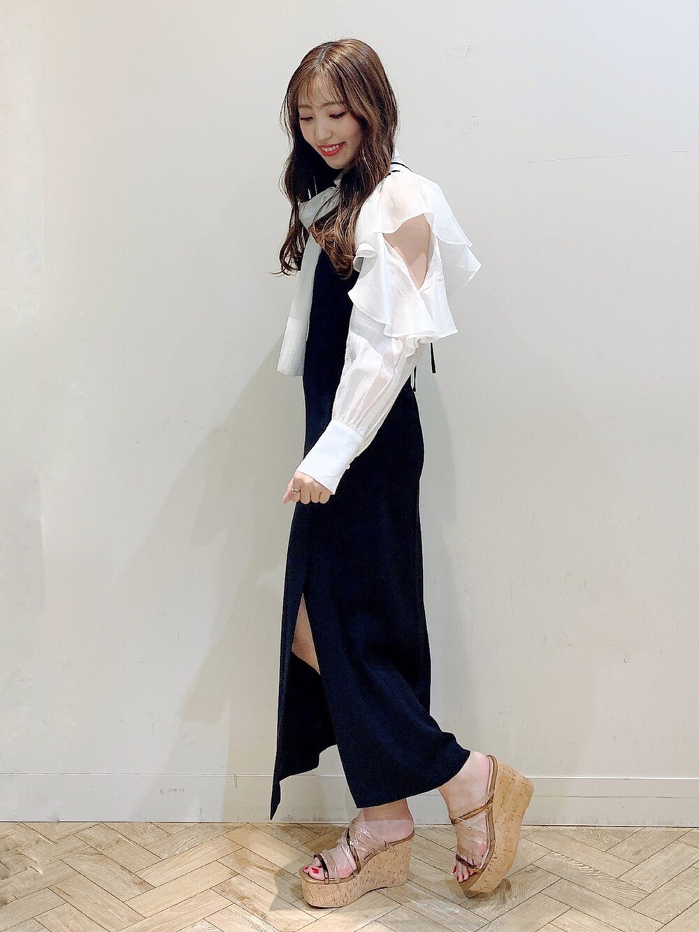 ブラック系のワンピース、ホワイト系のシャツ/ブラウス、ブラウン系のサンダルを着用したレディースの春コーディネートの4枚目の写真