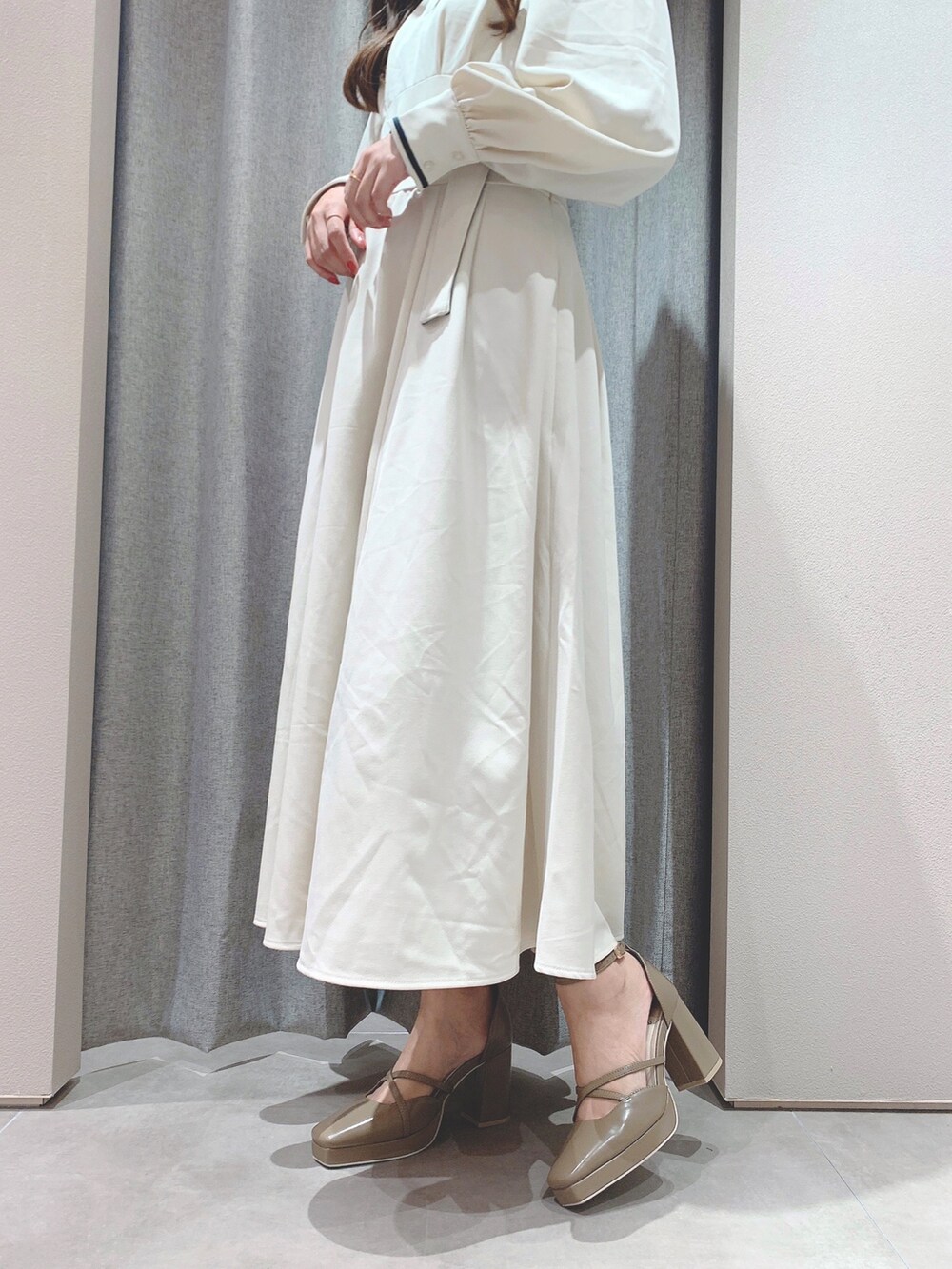 ホワイト系のワンピース、ベージュ系のパンプスを着用したレディースの秋コーディネートの8枚目の写真