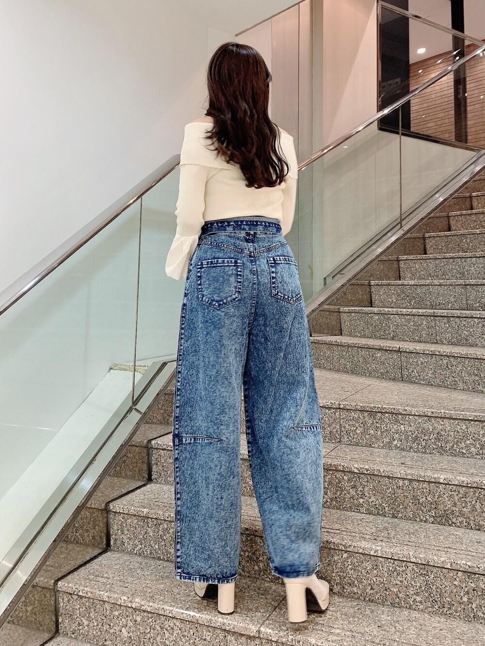 ホワイト系のニット/セーター、その他のデニムパンツ、ホワイト系のブーツを着用したレディースの冬コーディネートの6枚目の写真