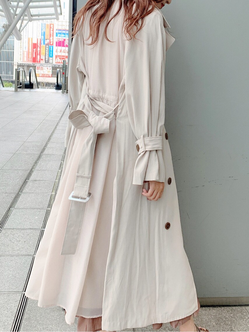 ベージュ系のトレンチコート、ブラウン系のワンピース、ベージュ系のサンダルを着用したレディースの春コーディネートの4枚目の写真