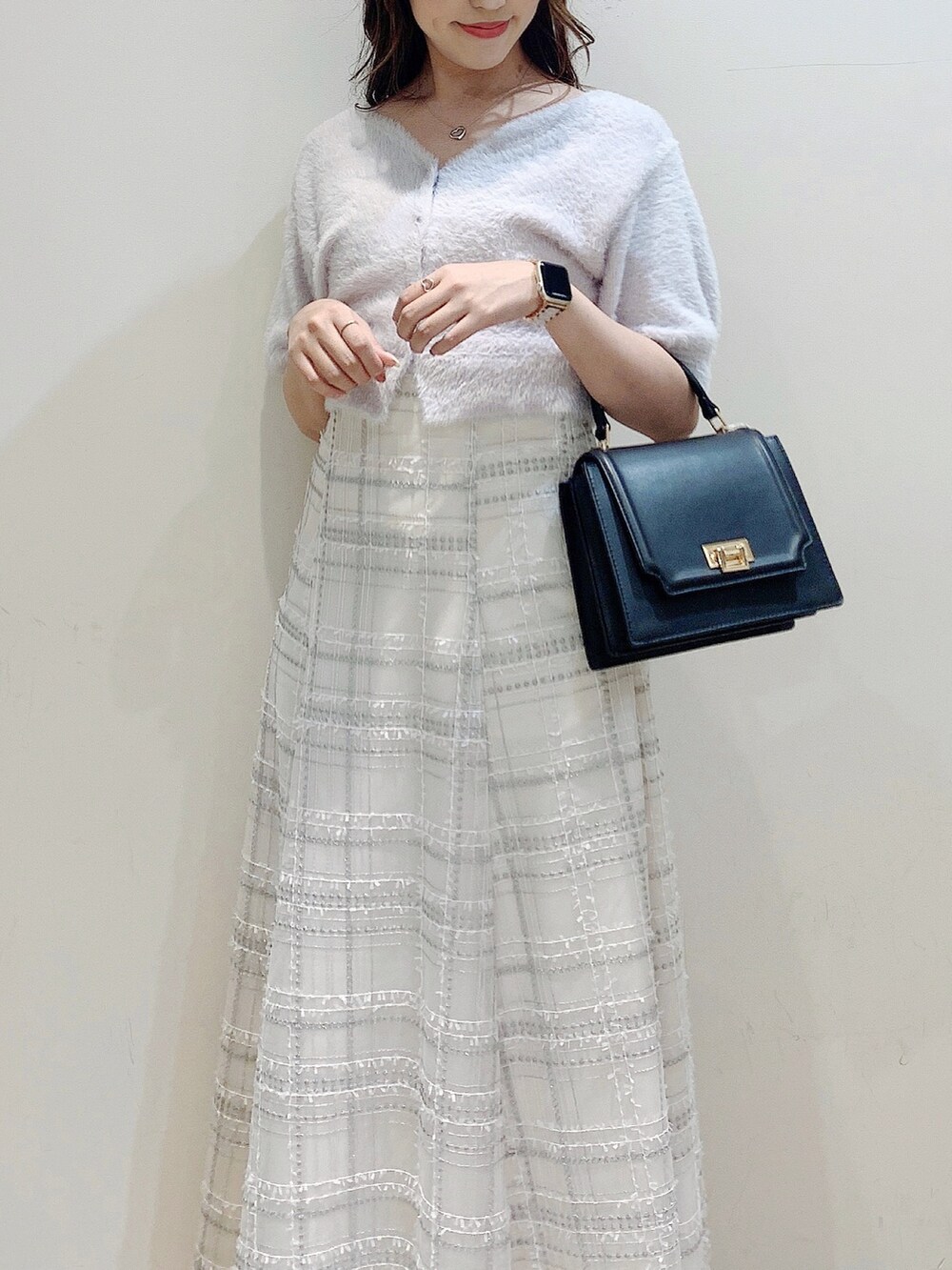 パープル系のカーディガン/ボレロ、ブラック系のスカート、ブラック系のパンプスを着用したレディースの夏コーディネートの7枚目の写真