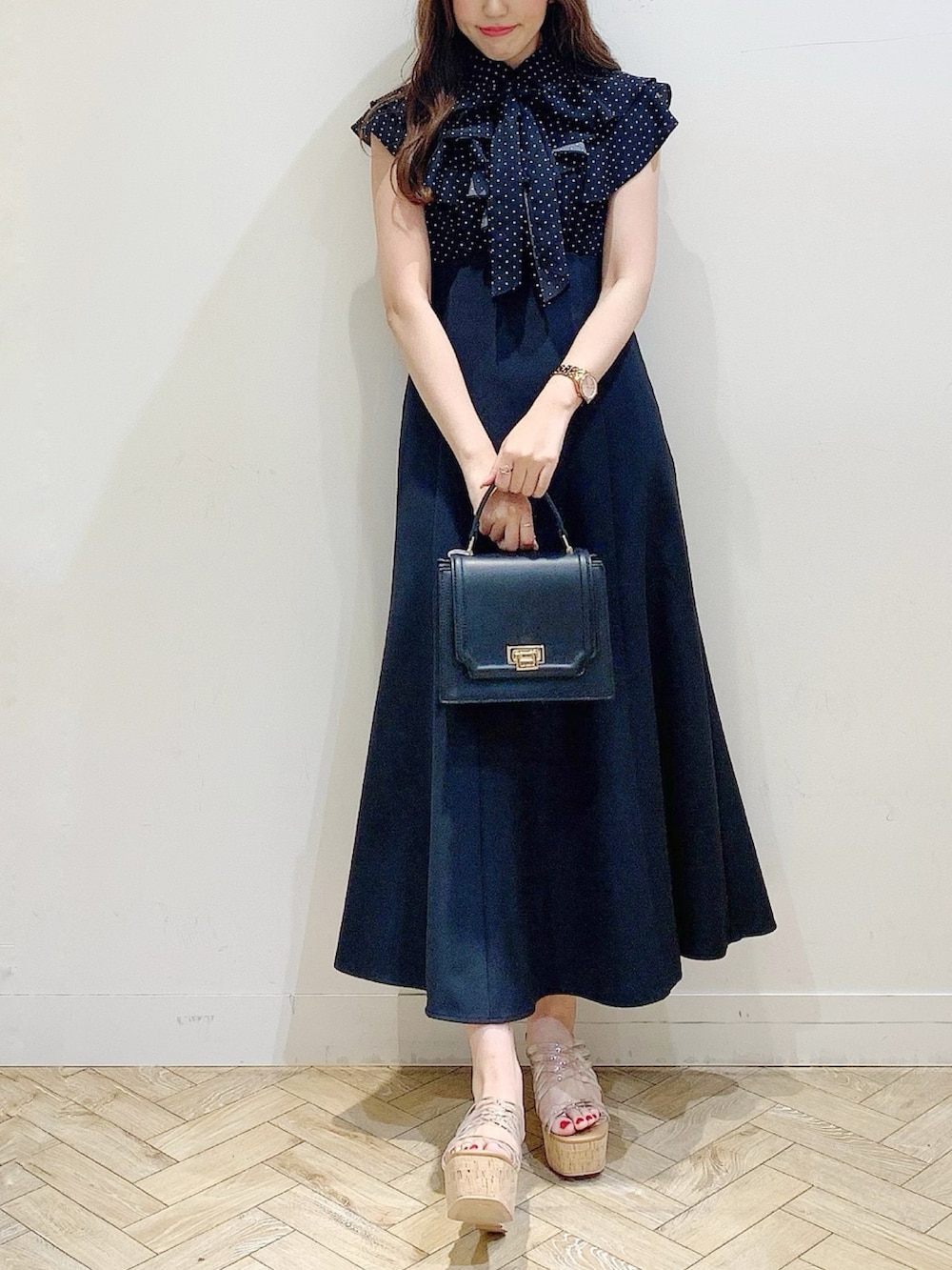 ブラック系のワンピース、その他のサンダル、ブラック系のハンドバッグを着用したレディースの春コーディネートの2枚目の写真