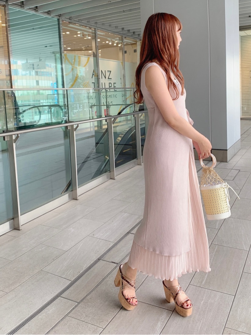 ホワイト系のハンドバッグ、ベージュ系のサンダル、ピンク系のワンピースを着用したレディースの春コーディネートの3枚目の写真