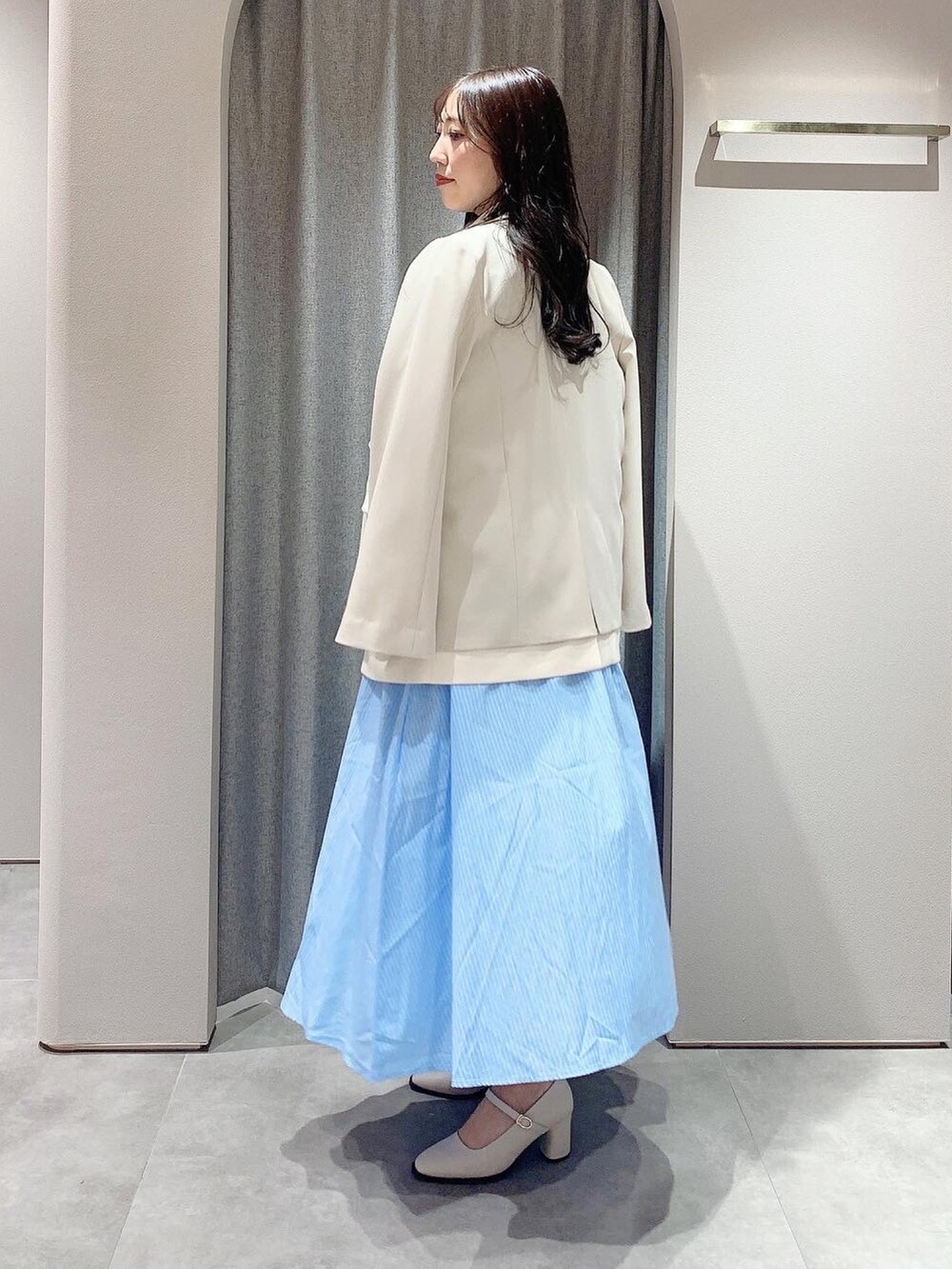 ブルー系のシャツワンピース、ホワイト系のテーラードジャケット、ホワイト系のパンプスを着用したレディースの冬コーディネートの8枚目の写真