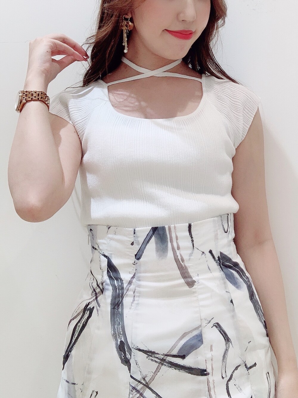 ホワイト系のニット/セーター、グレー系のスカート、ブラック系のサンダルを着用したレディースの夏コーディネートの7枚目の写真