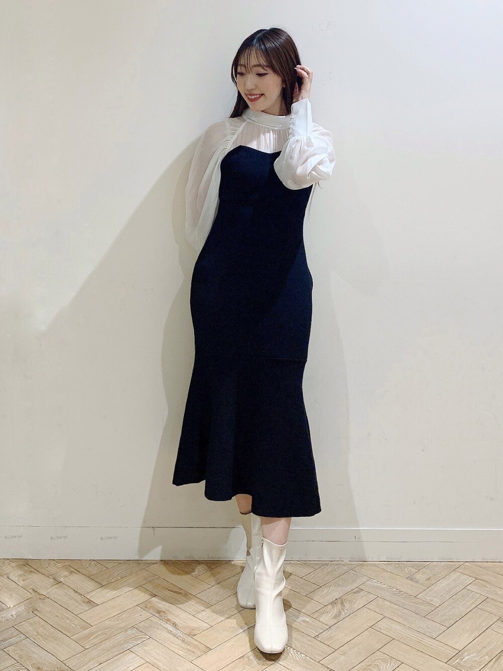 ブラック系のワンピース、ホワイト系のブーツを着用したレディースの冬コーディネートの3枚目の写真