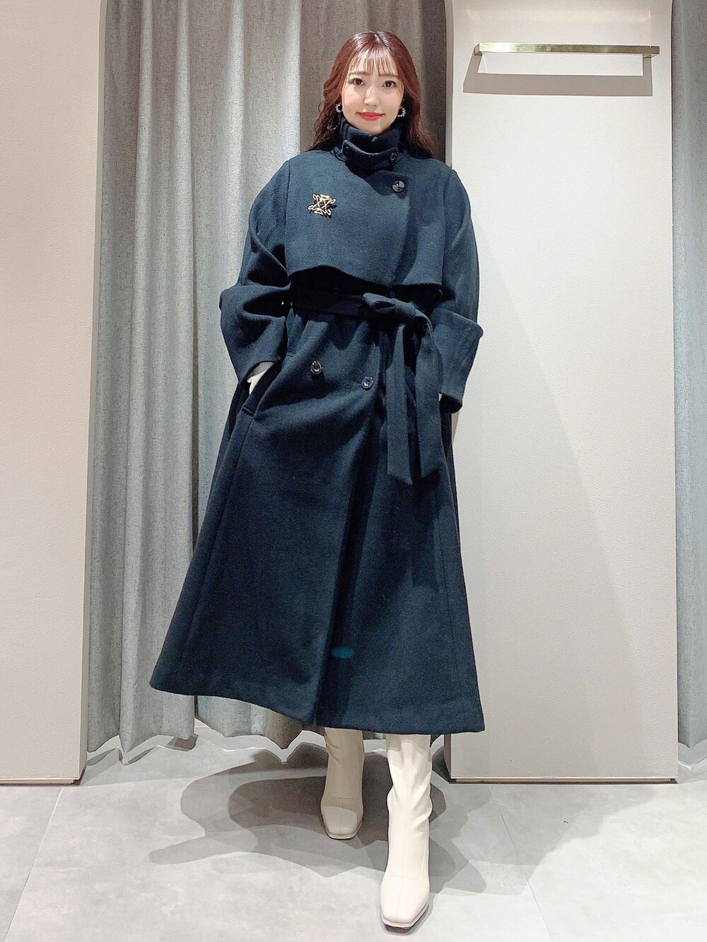 ホワイト系のワンピース、ホワイト系のブーツ、ブラック系のその他アウターを着用したレディースの冬コーディネートの5枚目の写真