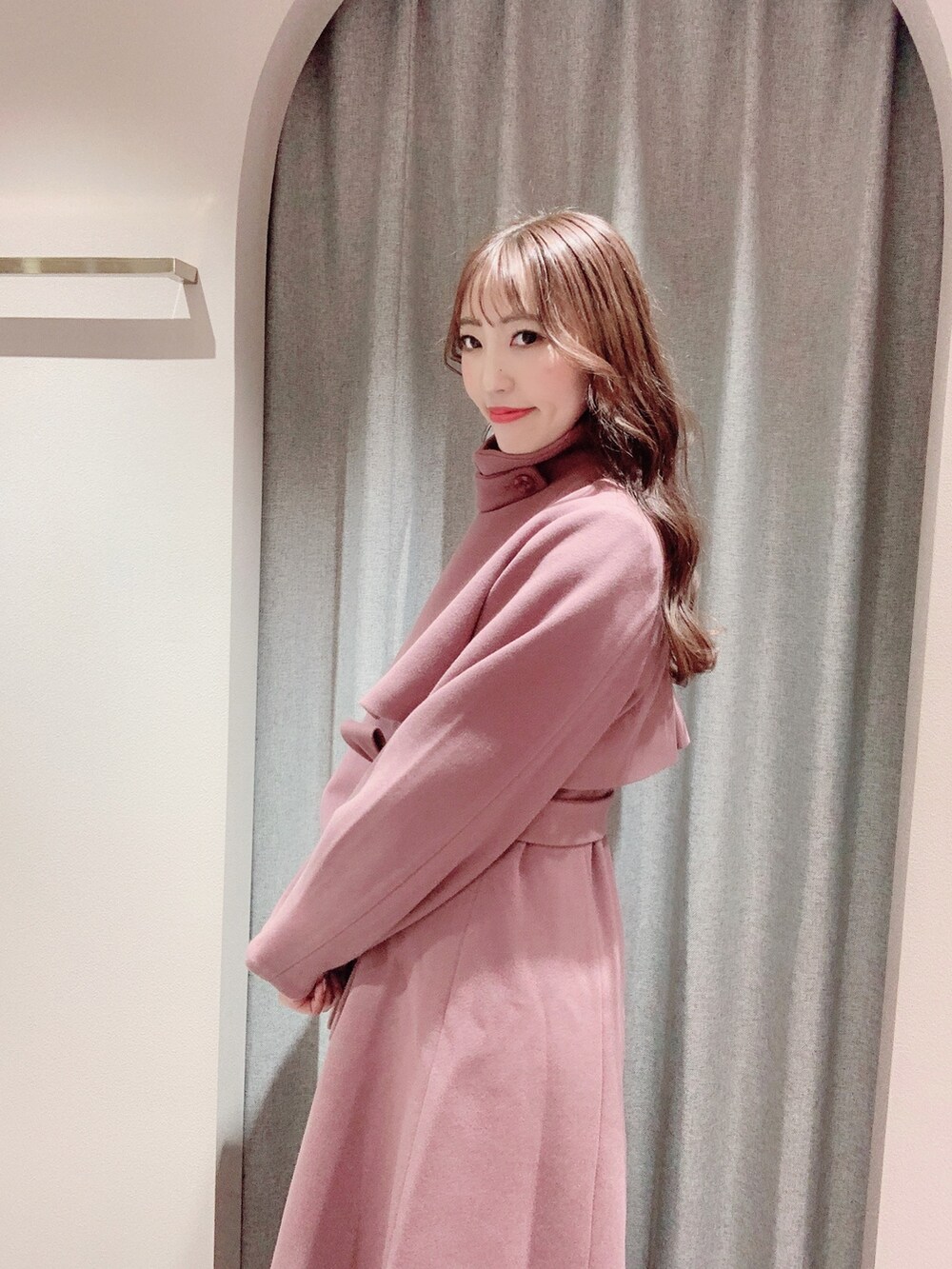 ピンク系のその他アウター、ホワイト系のブーツ、ホワイト系のニット/セーターを着用したレディースの秋コーディネートの8枚目の写真