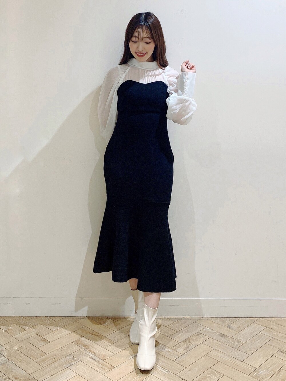 ブラック系のワンピース、ホワイト系のブーツを着用したレディースの冬コーディネートの4枚目の写真