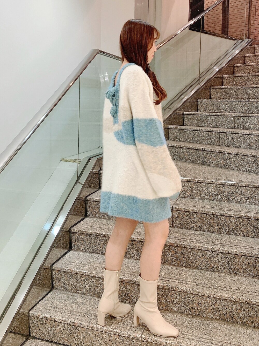 ベージュ系のニット/セーター、ホワイト系のブーツを着用したレディースの秋コーディネートの5枚目の写真