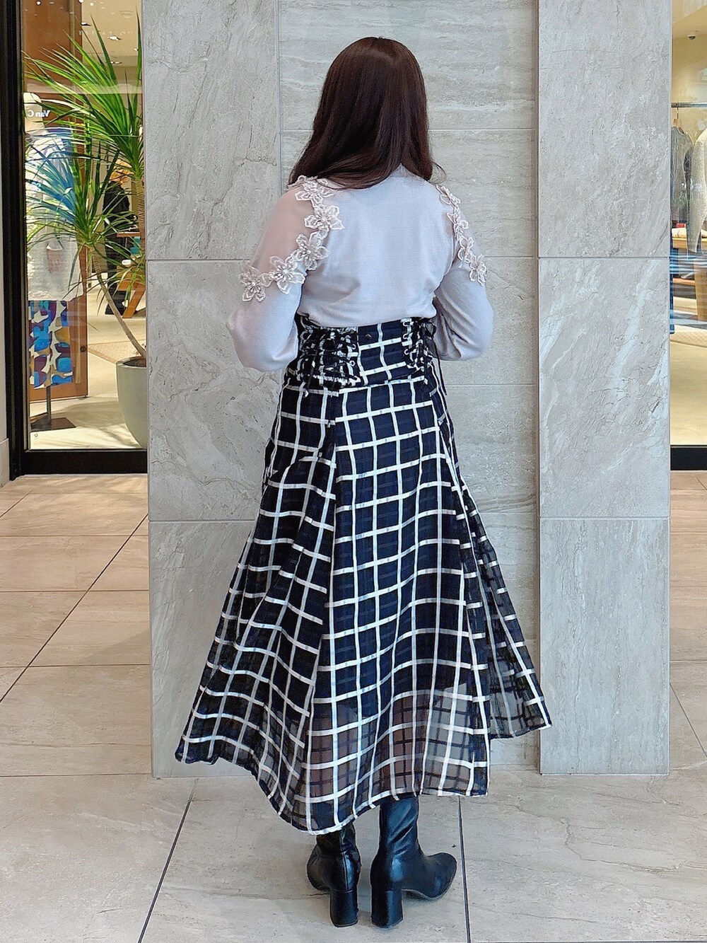 ブラック系のブーツ、ブラック系のスカート、ピンク系のニット/セーターを着用したレディースの冬コーディネートの5枚目の写真