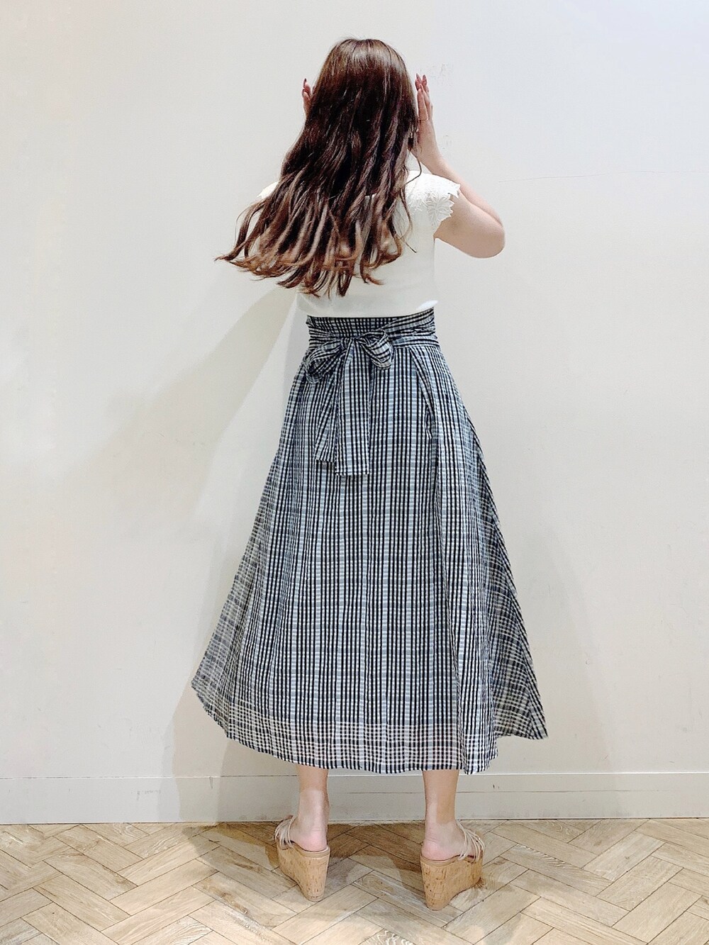 ブラック系のスカート、ホワイト系のニット/セーターを着用したレディースの夏コーディネートの5枚目の写真