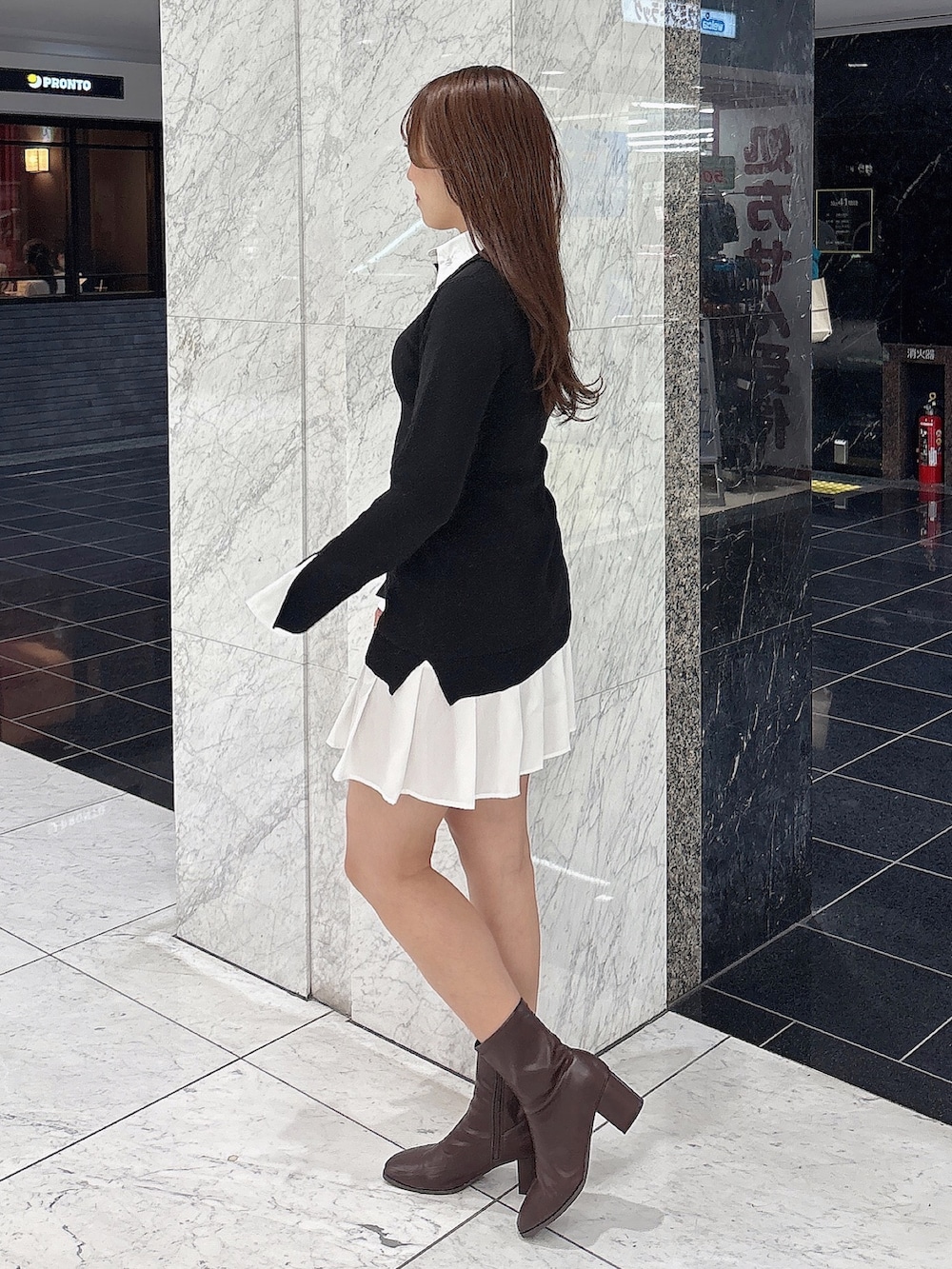 ブラック系のワンピース、ブラウン系のブーツを着用したレディースの秋コーディネートの5枚目の写真