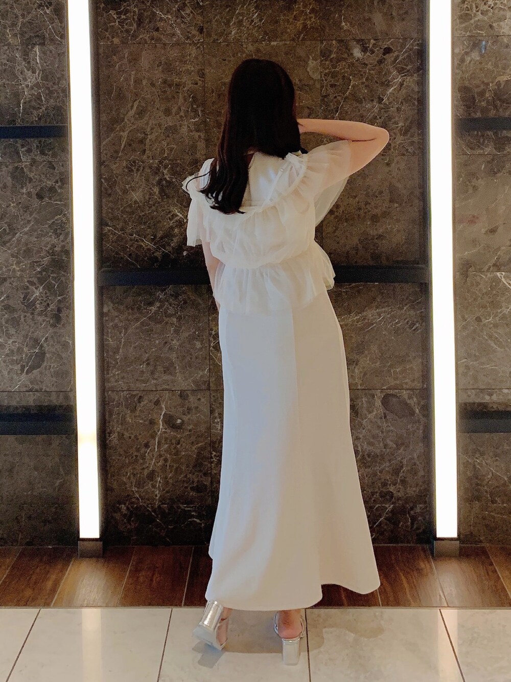 ホワイト系のワンピース、シルバー系のパンプスを着用したレディースの夏コーディネートの6枚目の写真