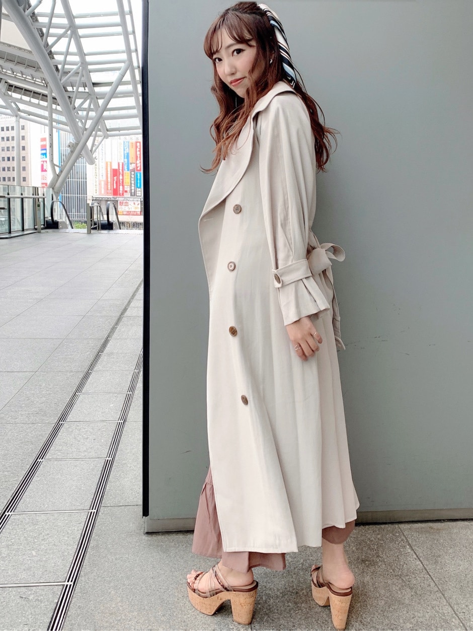 ベージュ系のトレンチコート、ブラウン系のワンピース、ベージュ系のサンダルを着用したレディースの春コーディネートの3枚目の写真