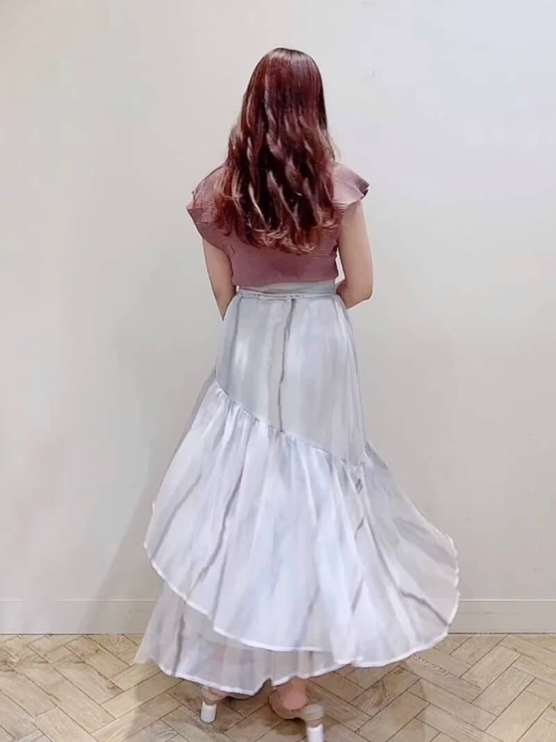 ピンク系のスカート、ブラウン系のニット/セーター、ベージュ系のサンダルを着用したレディースの夏コーディネートの4枚目の写真