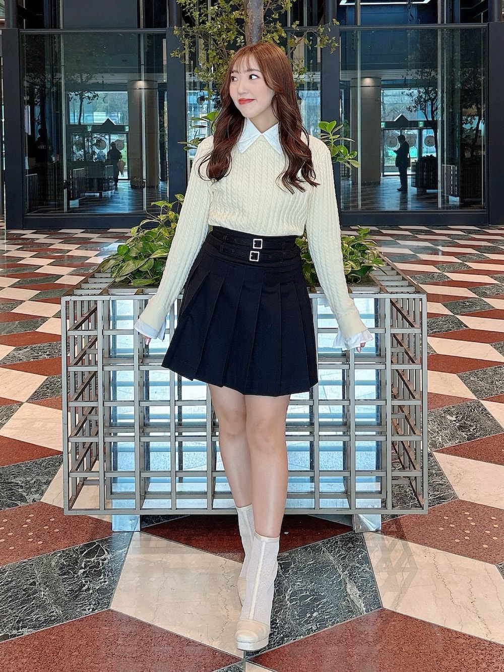 ホワイト系のブーツ、ブラック系のスカート、ホワイト系のニット/セーターを着用したレディースの冬コーディネートの3枚目の写真