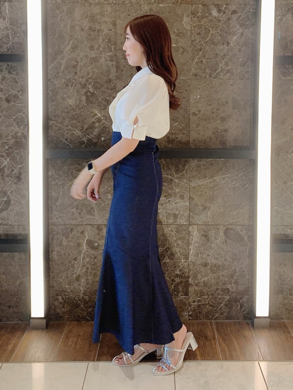 シルバー系のパンプス、ブルー系のスカート、ホワイト系のシャツ/ブラウスを着用したレディースの夏コーディネートの4枚目の写真