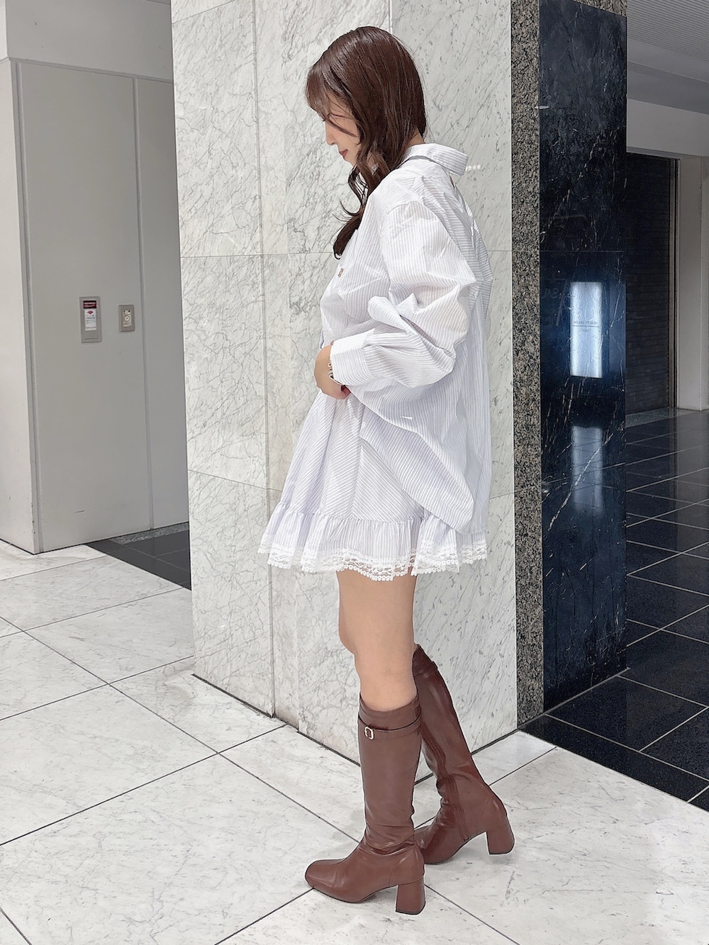 ブラウン系のブーツ、ホワイト系のシャツ/ブラウス、ホワイト系のスカートを着用したレディースの春コーディネートの3枚目の写真
