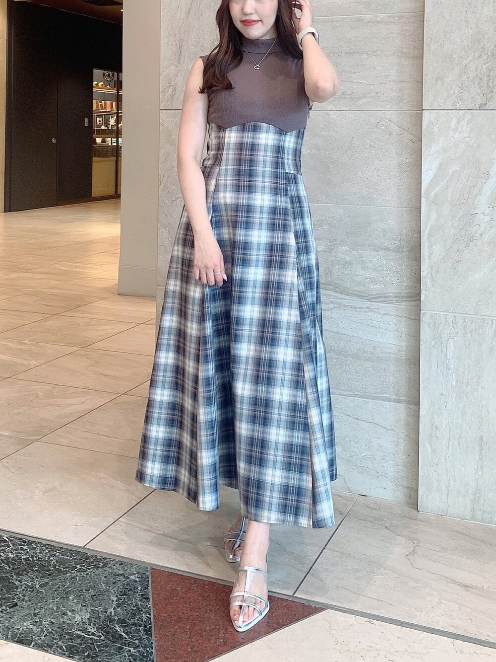 シルバー系のパンプス、ベージュ系のワンピースを着用したレディースの夏コーディネートの2枚目の写真