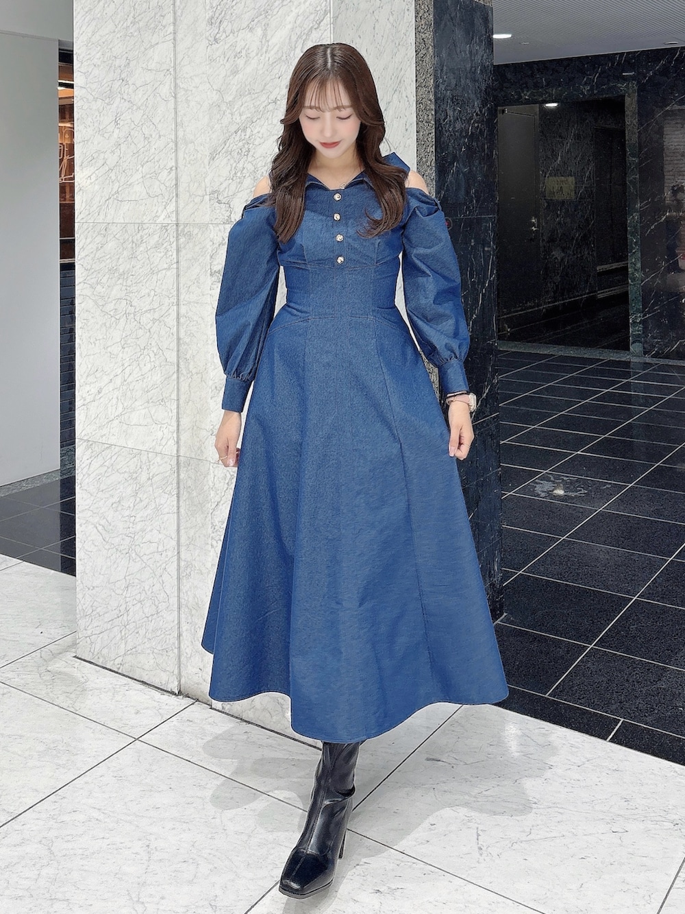 ブルー系のワンピース、ブラック系のブーツを着用したレディースの冬コーディネートの2枚目の写真