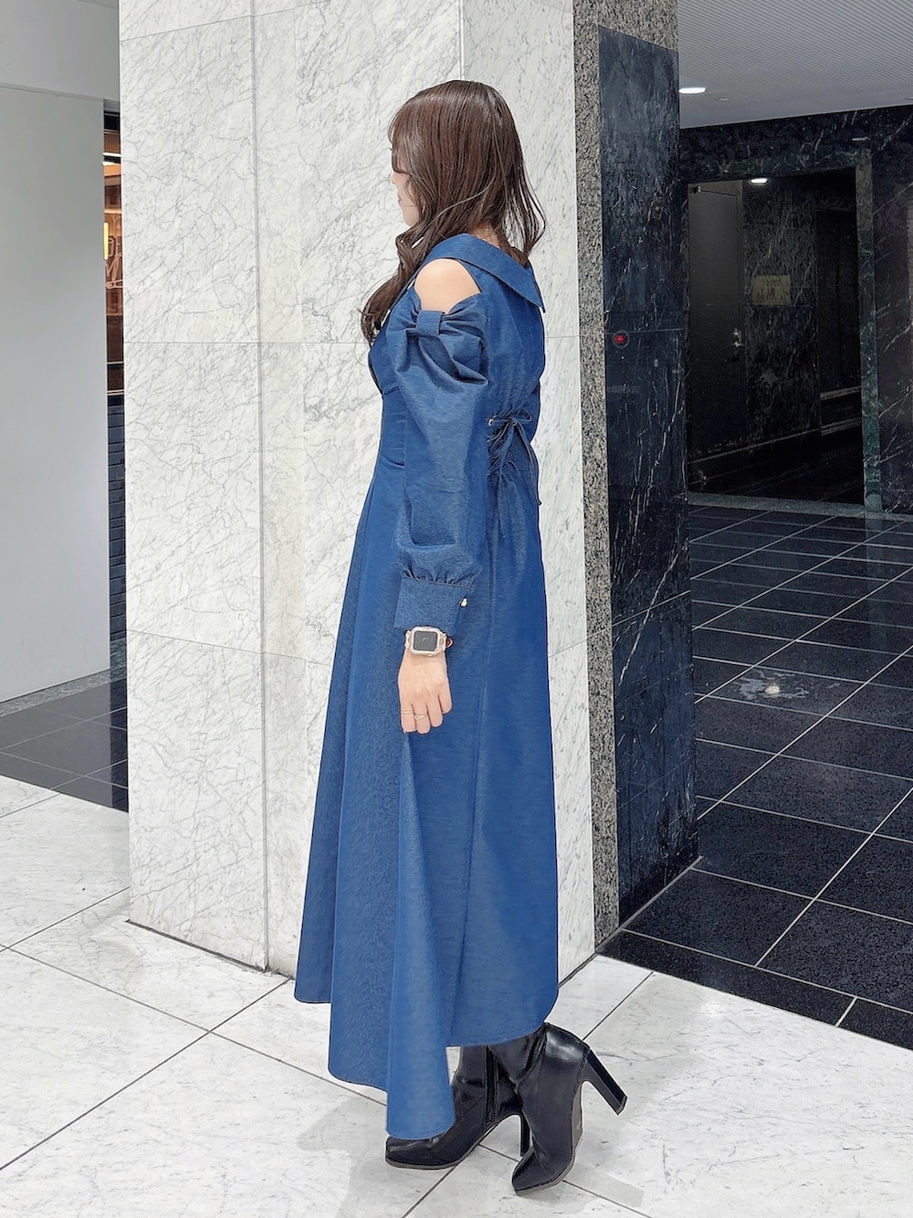 ブルー系のワンピース、ブラック系のブーツを着用したレディースの冬コーディネートの4枚目の写真