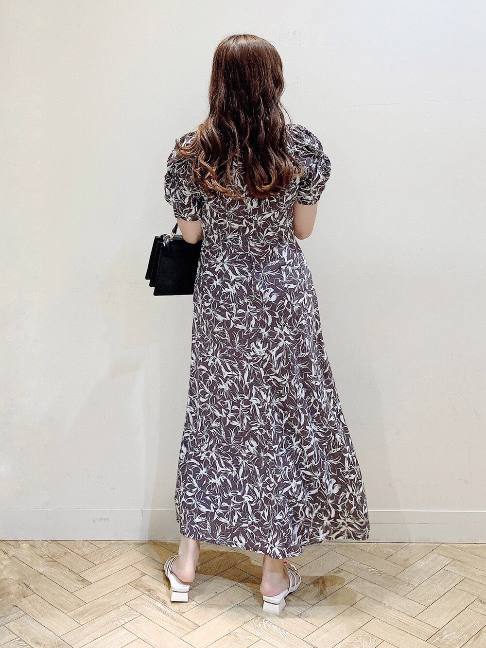 グレー系のワンピース、ホワイト系のサンダル、ブラック系のハンドバッグを着用したレディースの春コーディネートの6枚目の写真