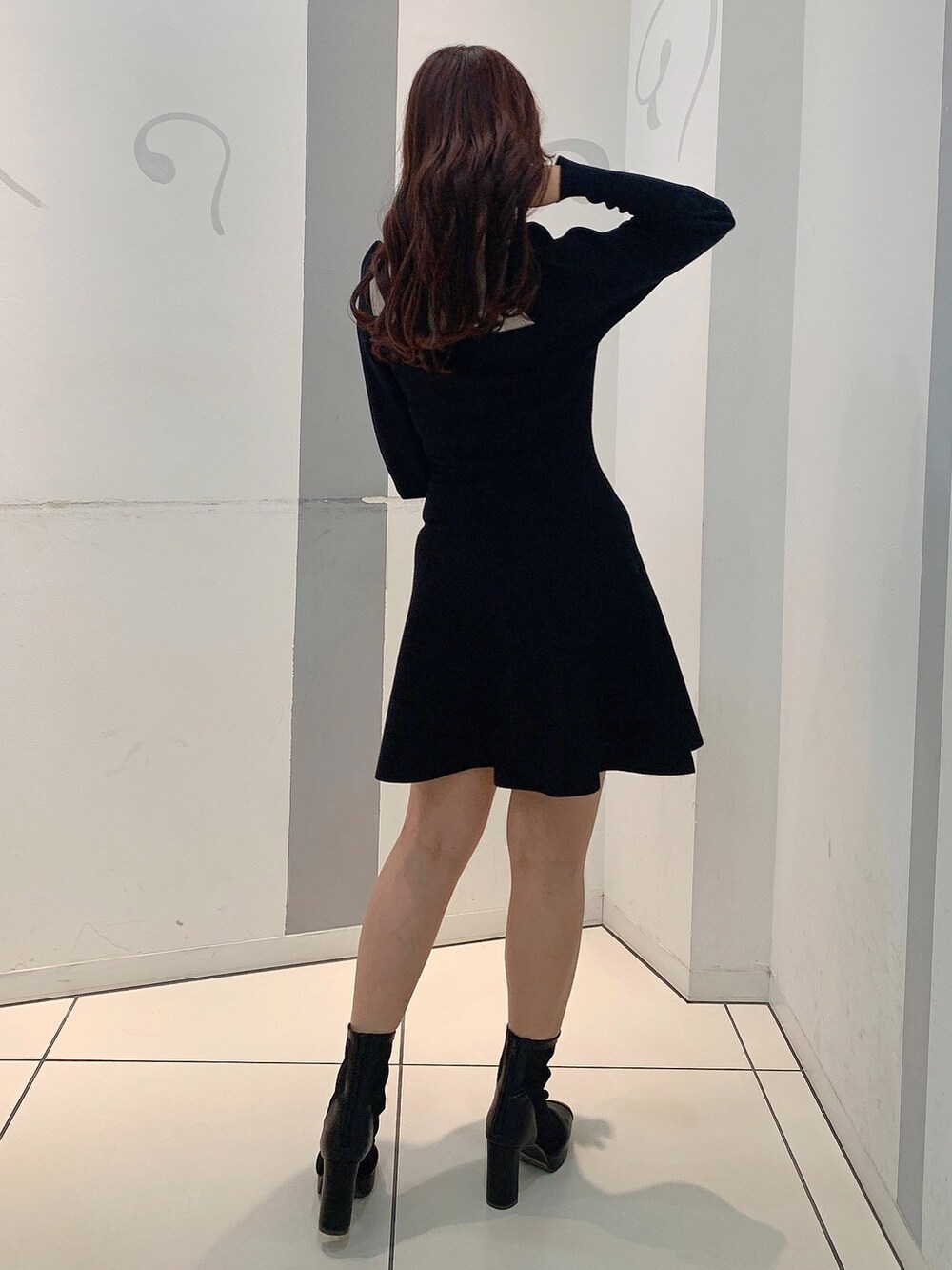 ブラック系のワンピース、ブラック系のブーツを着用したレディースの冬コーディネートの5枚目の写真