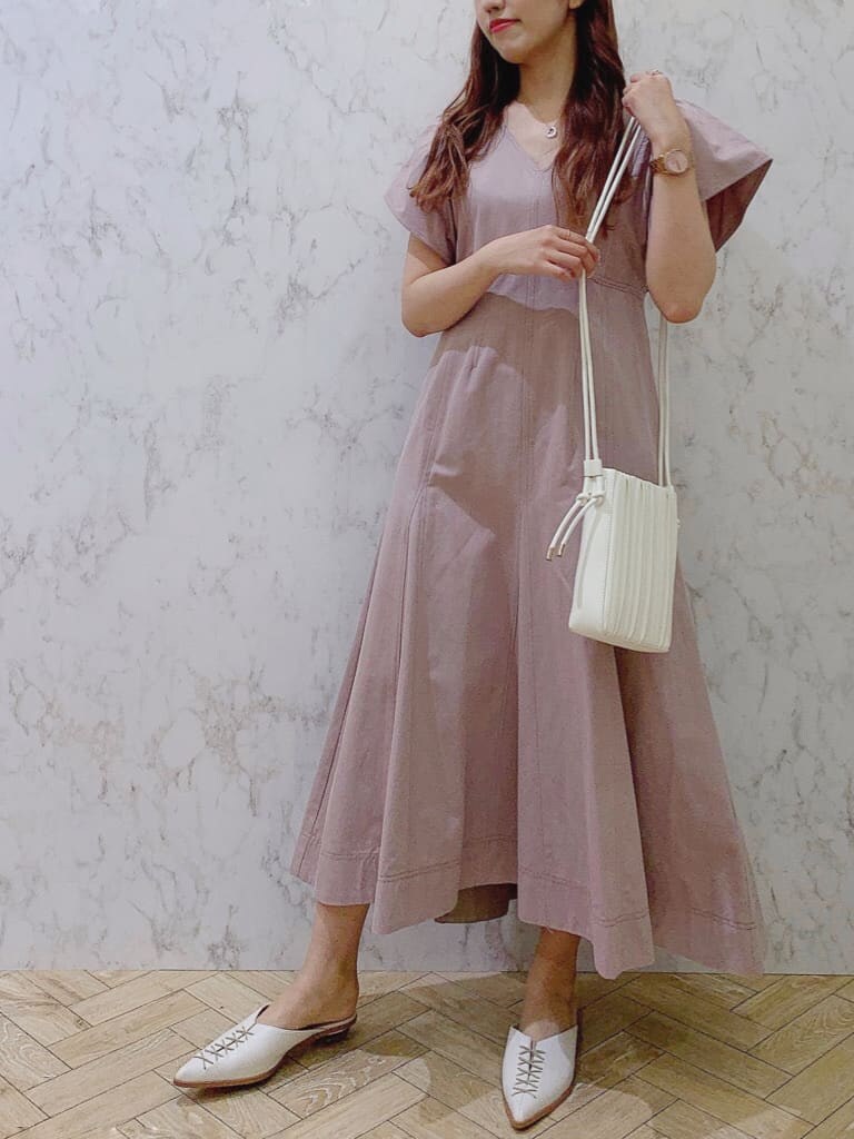ベージュ系のワンピース、ホワイト系のサンダル、ホワイト系のハンドバッグを着用したレディースの夏コーディネートの2枚目の写真