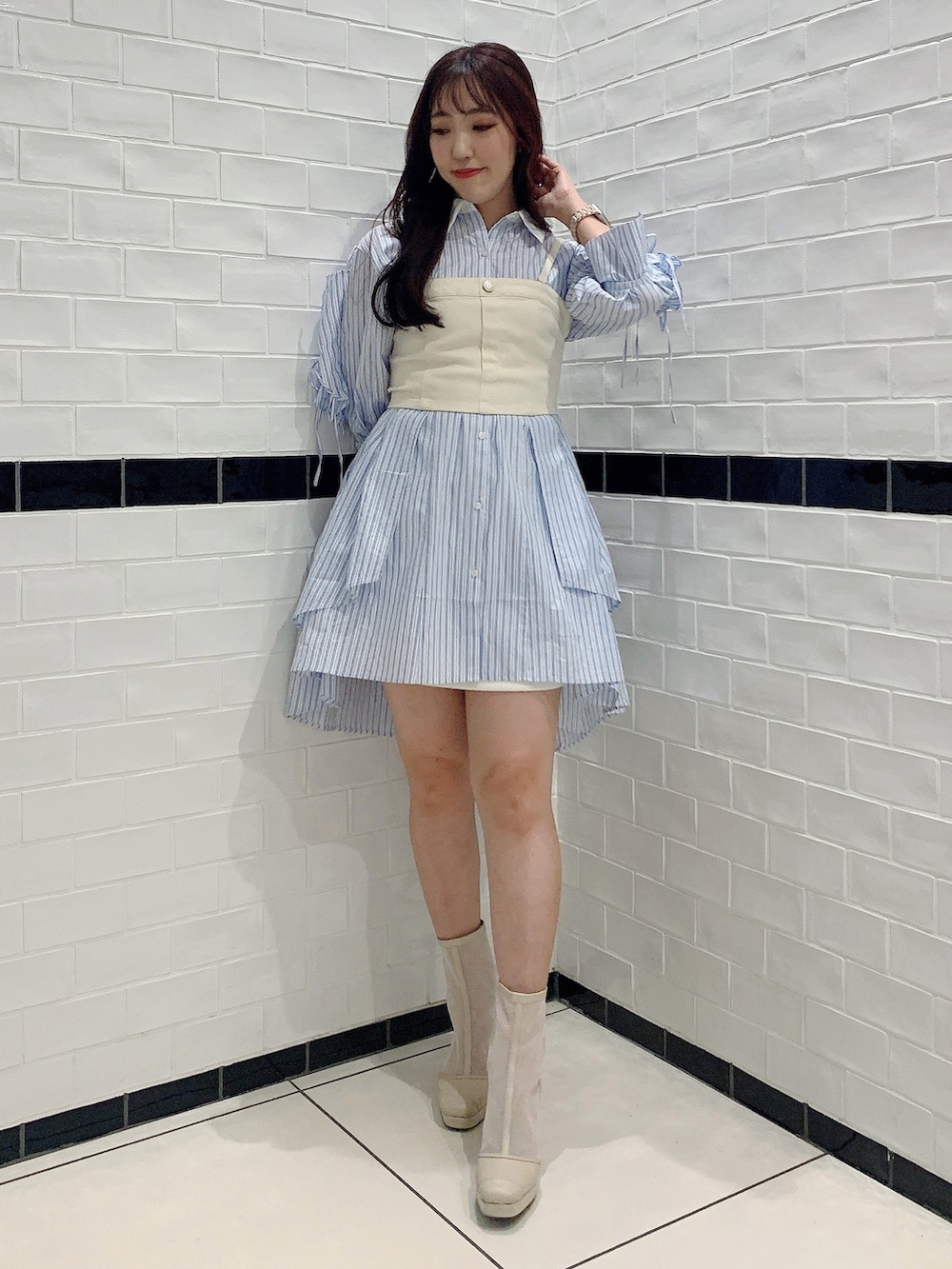 ブルー系のシャツワンピース、ホワイト系のブーツ、ホワイト系のキャミソールを着用したレディースの春コーディネートの4枚目の写真