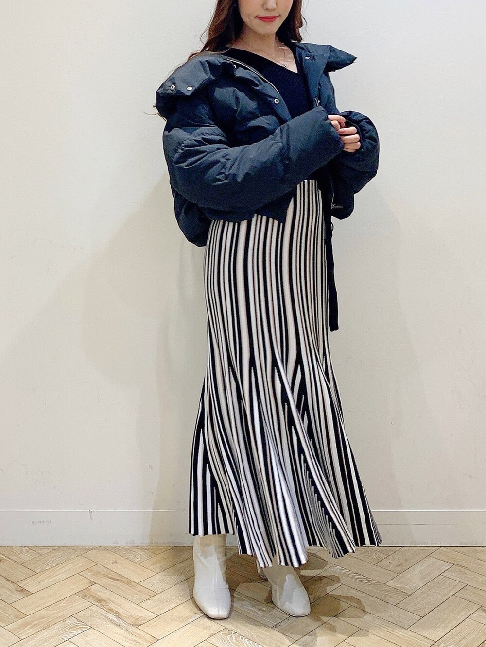 ブラック系のワンピース、ブラック系のダウンジャケット/コート、ホワイト系のブーツを着用したレディースの冬コーディネートの7枚目の写真