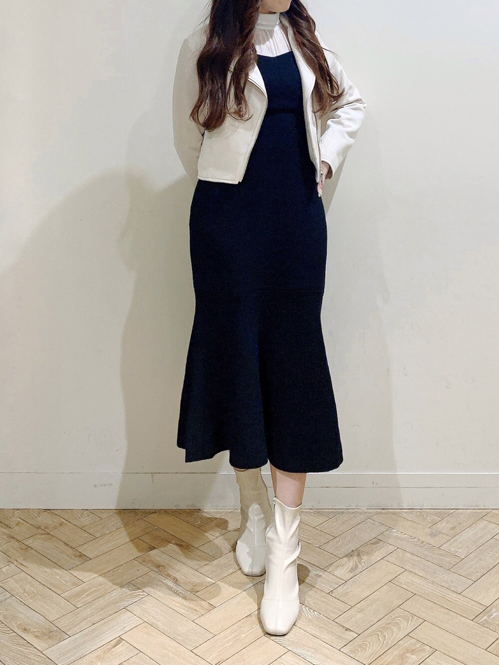 ブラック系のワンピース、ホワイト系のブーツ、ベージュ系のライダースジャケットを着用したレディースの冬コーディネートの5枚目の写真