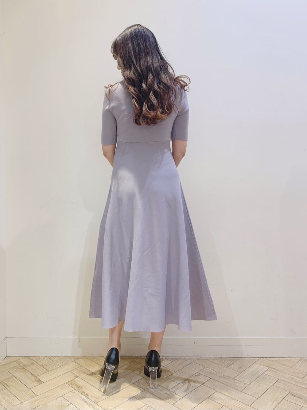 ブラック系のパンプス、パープル系のワンピースを着用したレディースの春コーディネートの3枚目の写真