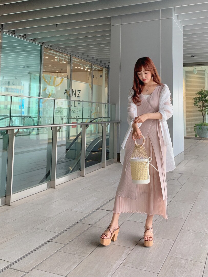 ホワイト系のハンドバッグ、ベージュ系のサンダル、ピンク系のワンピースを着用したレディースの春コーディネートの2枚目の写真