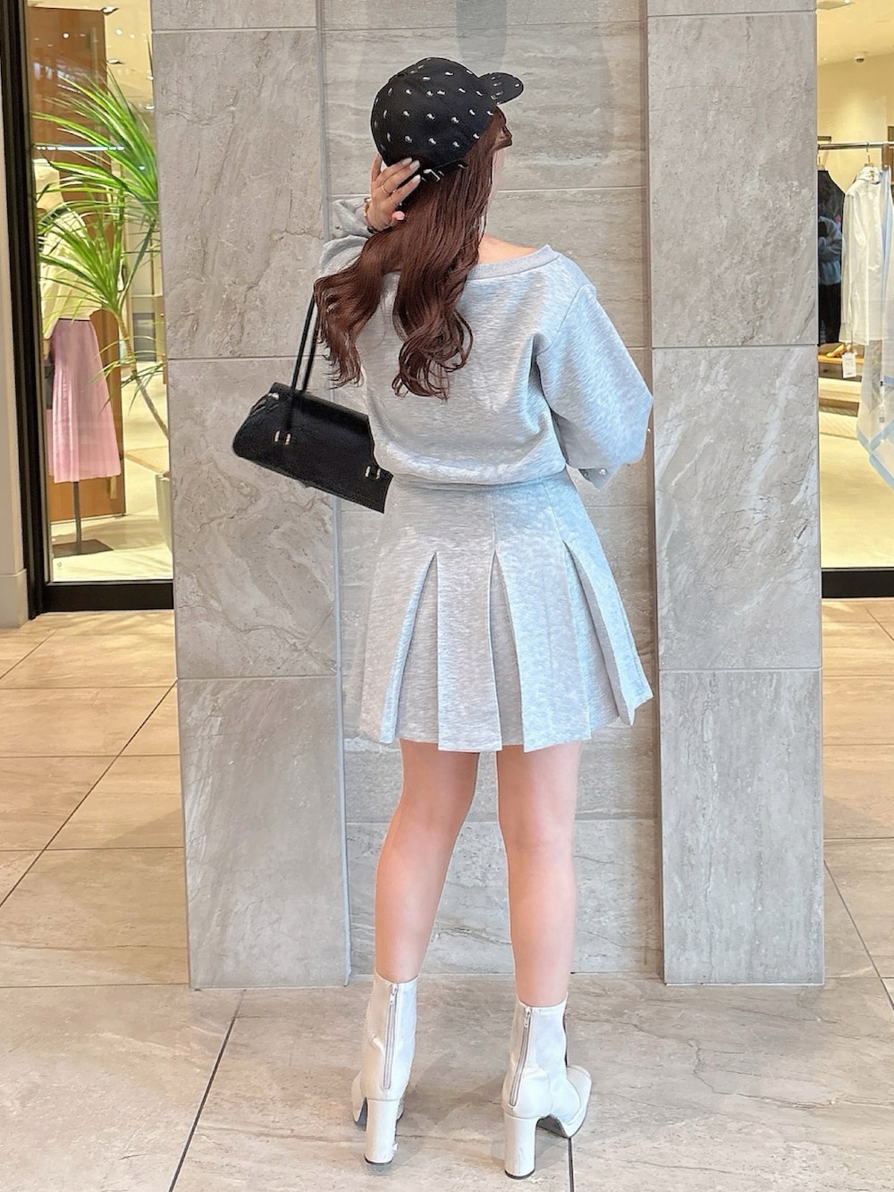 ホワイト系のブーツ、グレー系のスカート、グレー系のスウェットを着用したレディースの春コーディネートの4枚目の写真